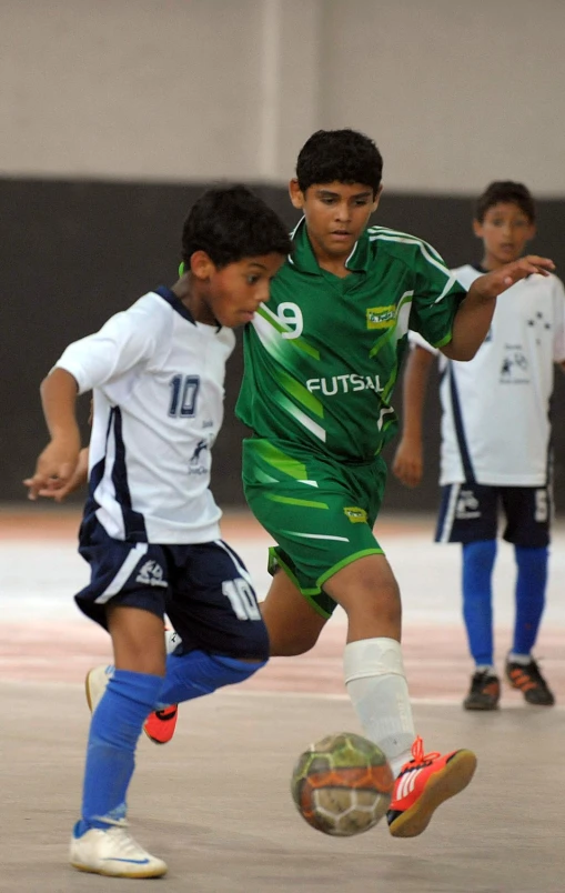 two s playing soccer on a sports field