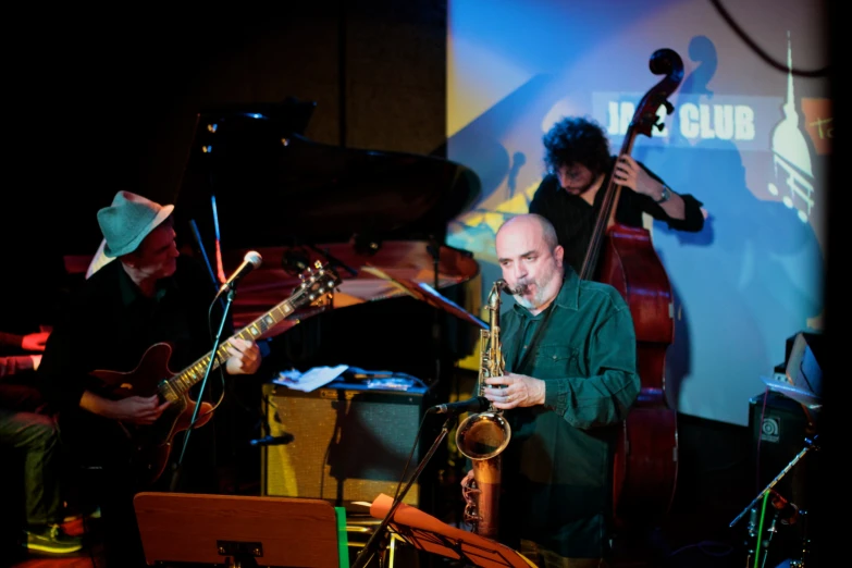 a man playing saxophone while others look on