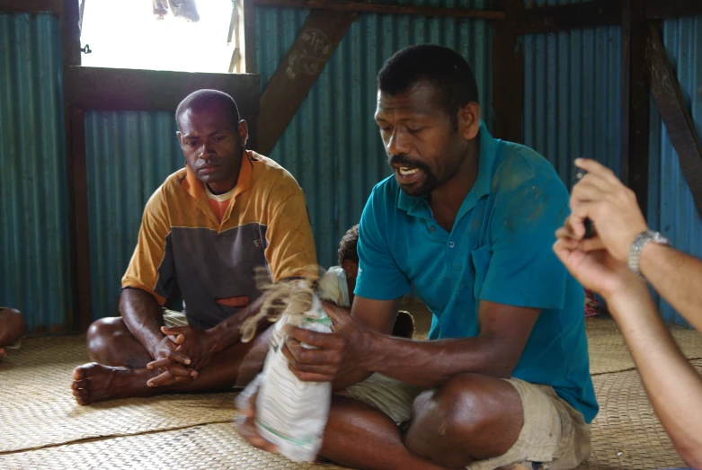 a group of people in a house with a bag of rice