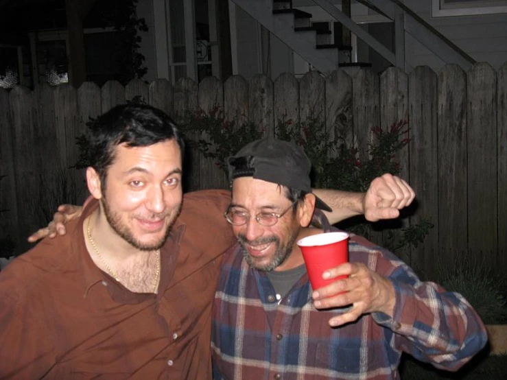 two men one holding up a red cup