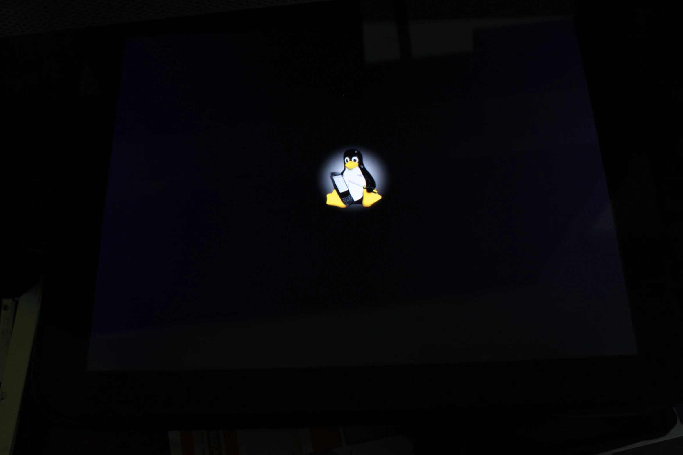 the dark side of the screen is showing a yellow and black penguin logo