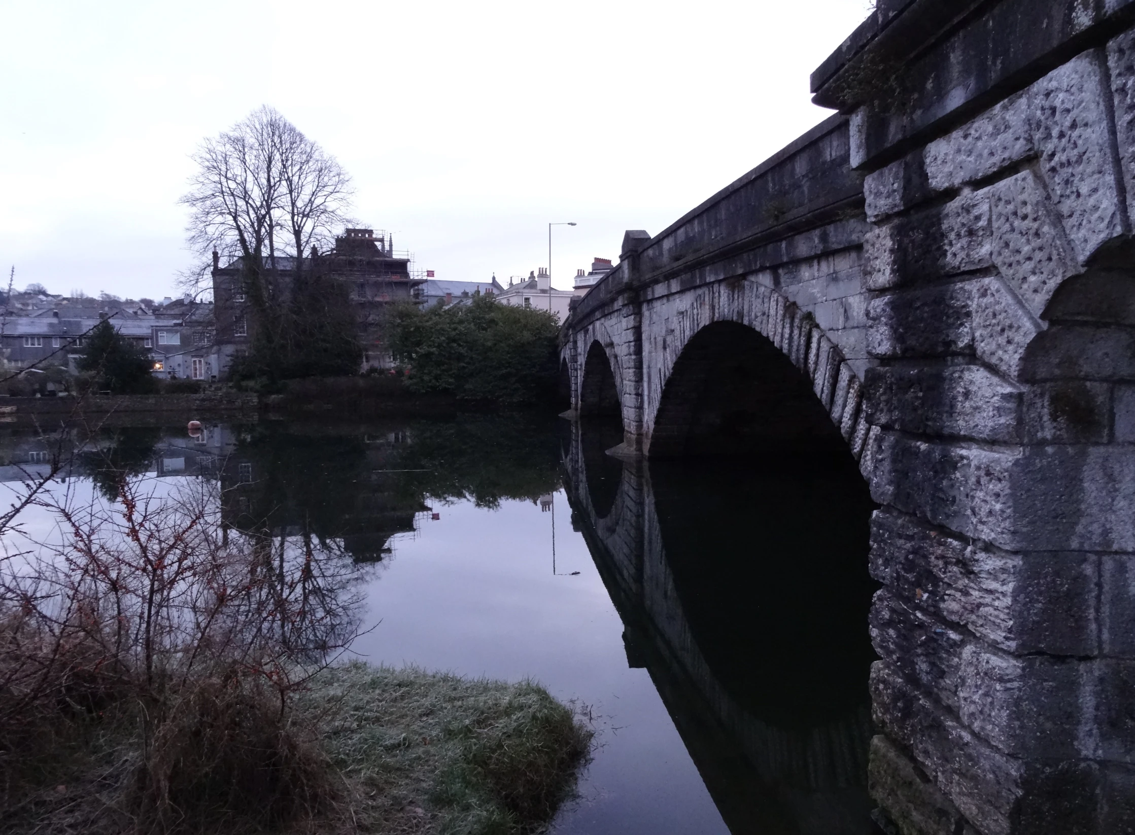 a bridge over a body of water with a city in the distance