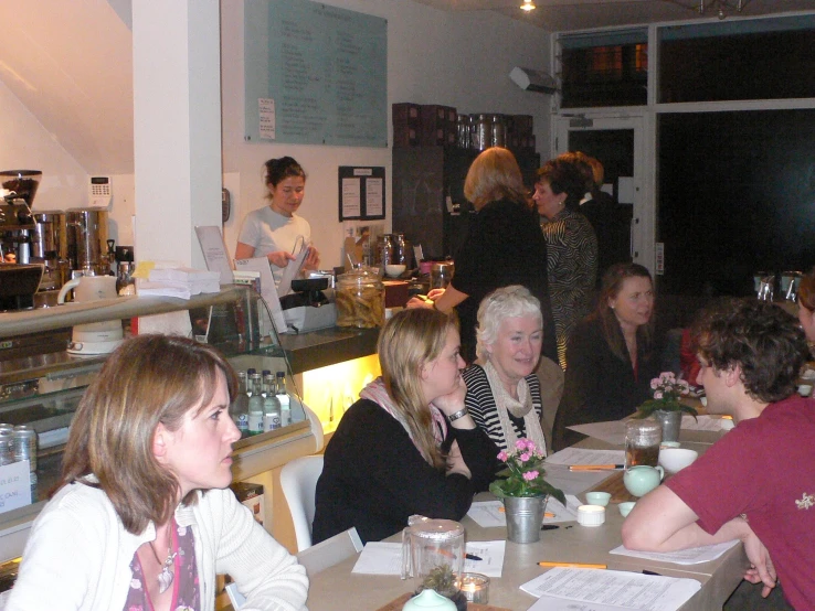 group of people sitting at long tables with beverages