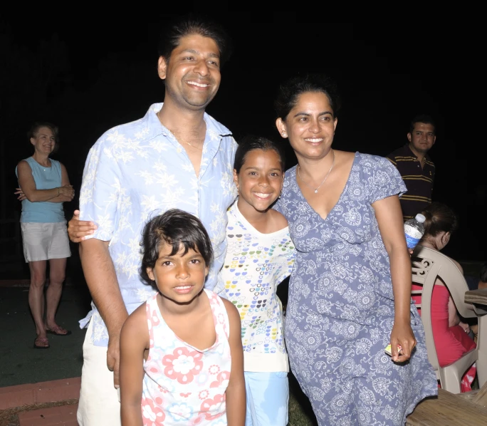 a couple with children and adults in a dark lit setting