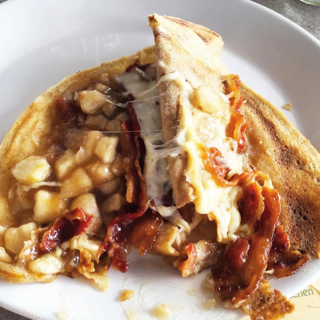 a crepe with meat and cheese sits on a plate