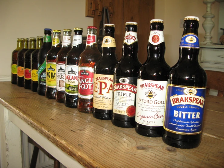 a row of different flavored beer bottles on a table