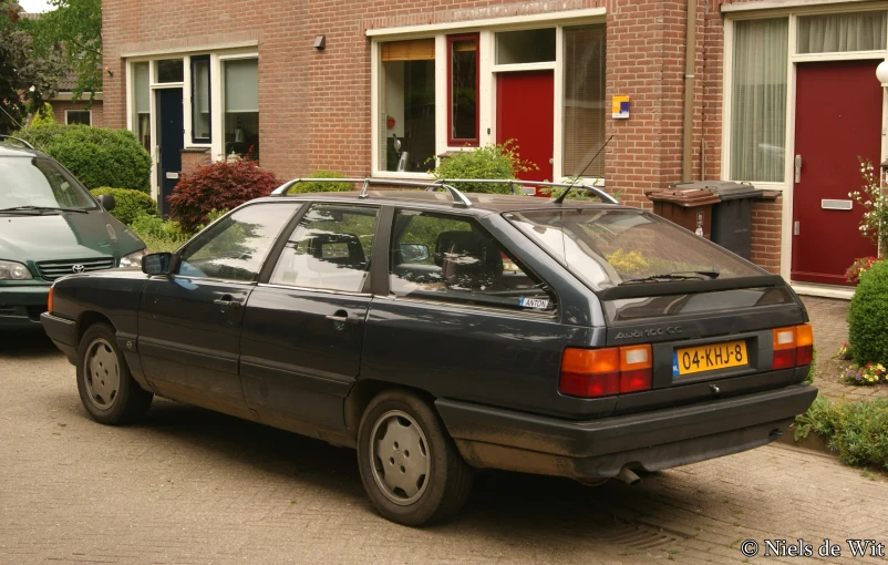 a small car is parked in front of brick buildings