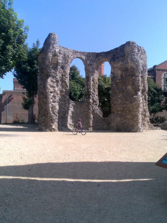 a woman with a bicycle in front of an old building