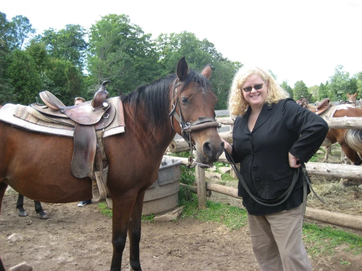 a smiling woman is posing with two horses