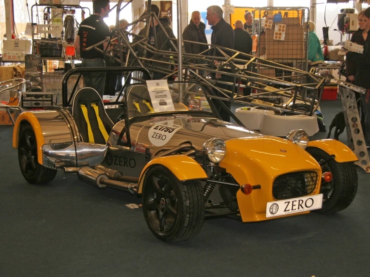 some people and their cars on display in a building