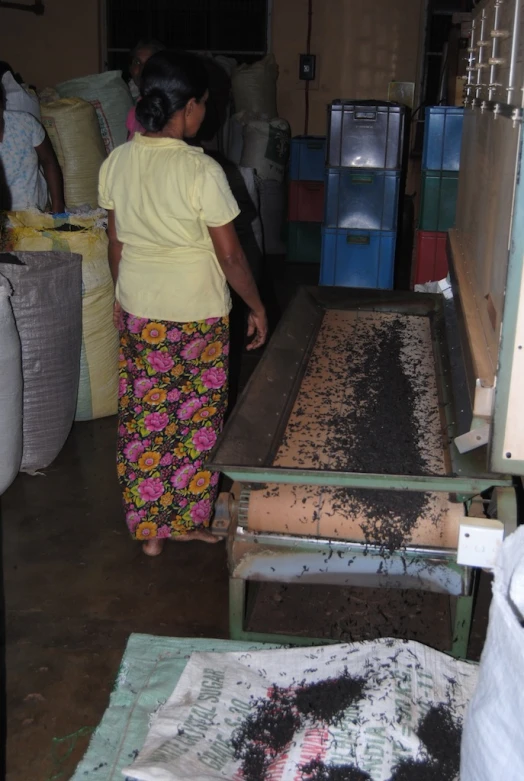 a woman moving a piece of wood over a weaving machine