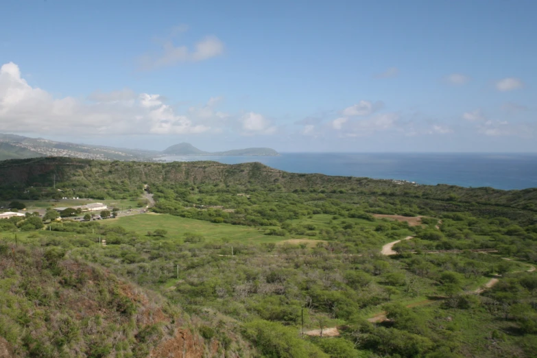 an overhead view of the ocean with green land