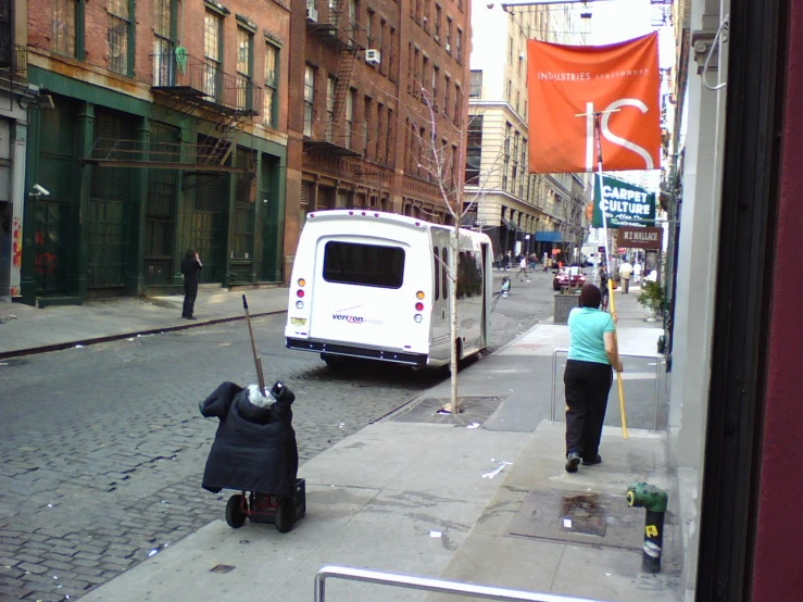 a white van is on the street by a person and another person with a dog