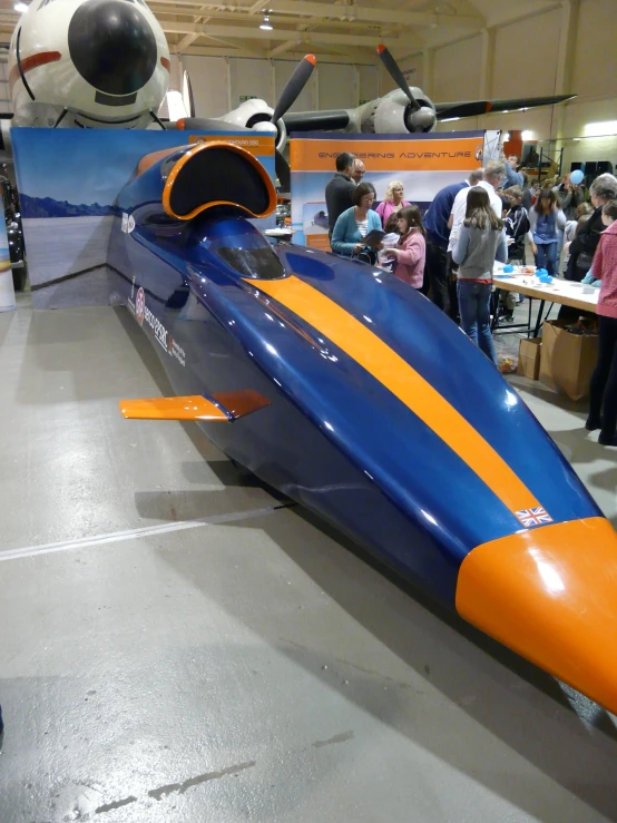 a futuristic vehicle at an outdoor event in a hangar