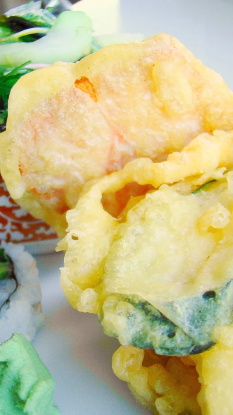 a white plate holding a couple of green and yellow desserts