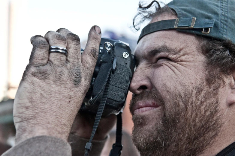 man holding a black camera up in front of his face