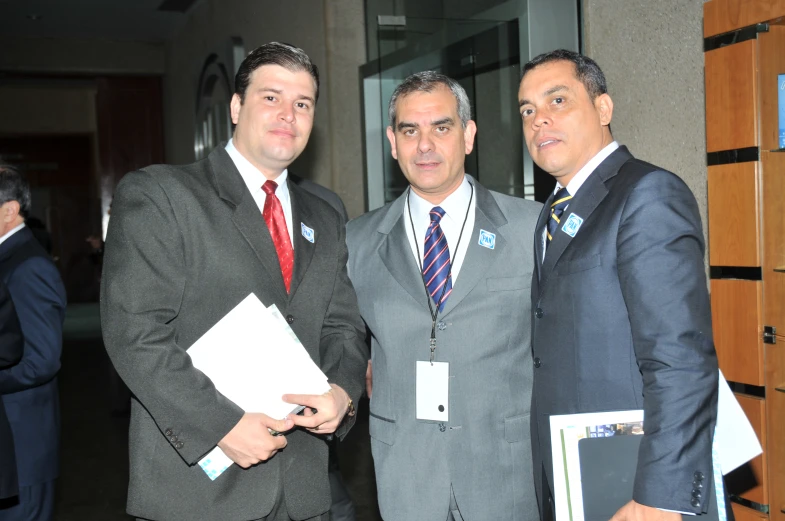three men dressed in suits and ties standing together