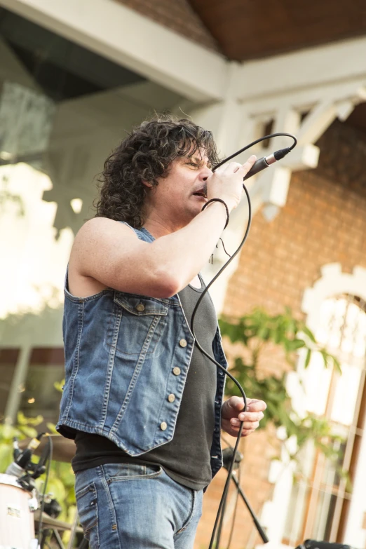 a man on stage with his hands on microphone