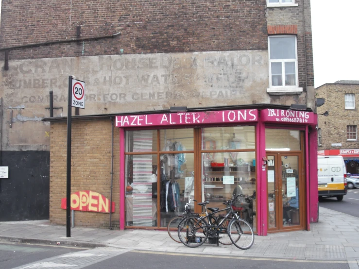 two bicycles parked outside of a store in front of an open window