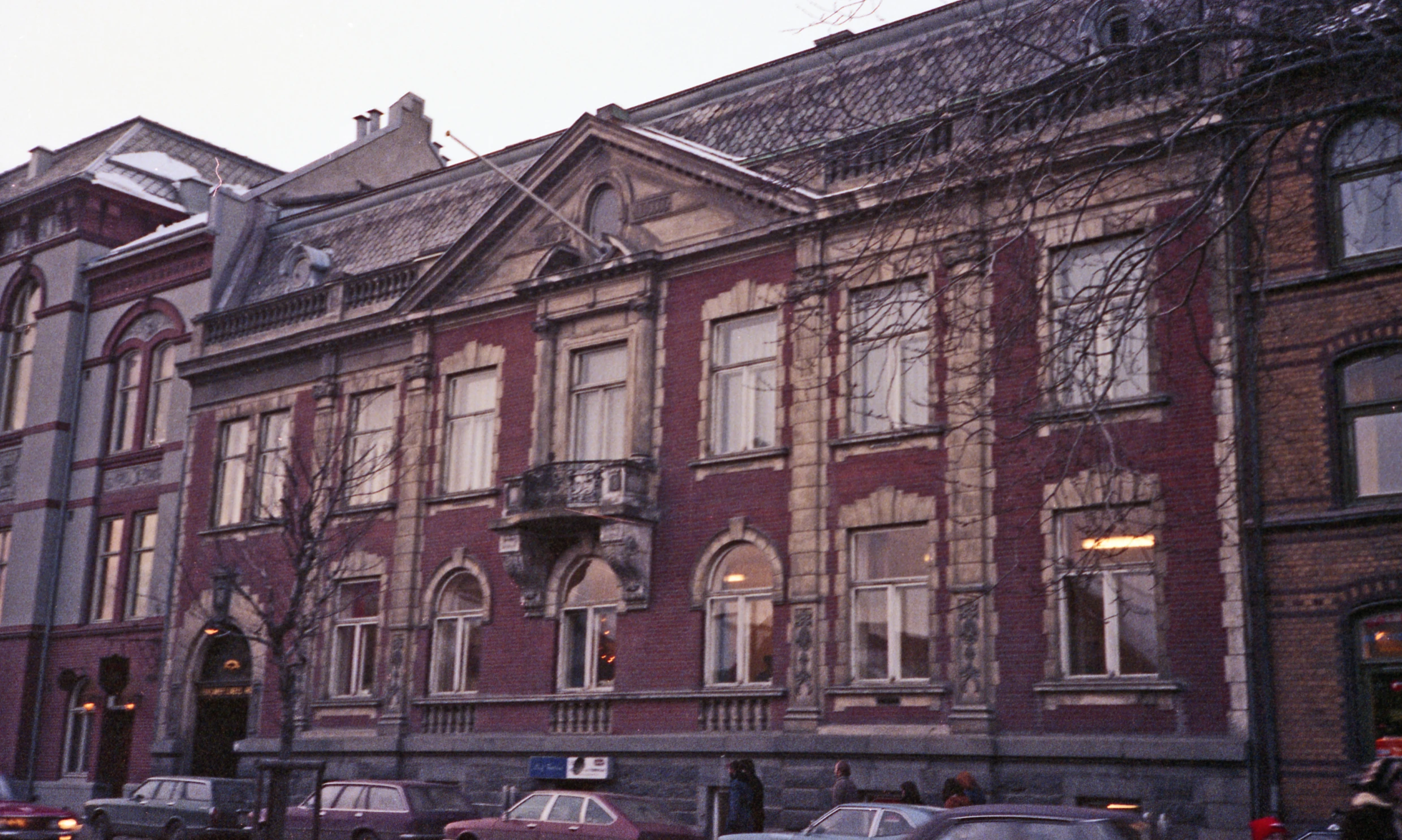 an old building sits in a residential area with snow on the top