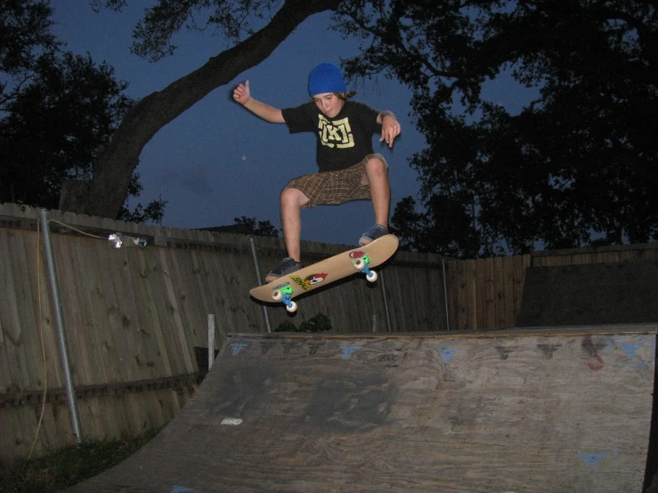 skate boarder making a jump on concrete block with fence