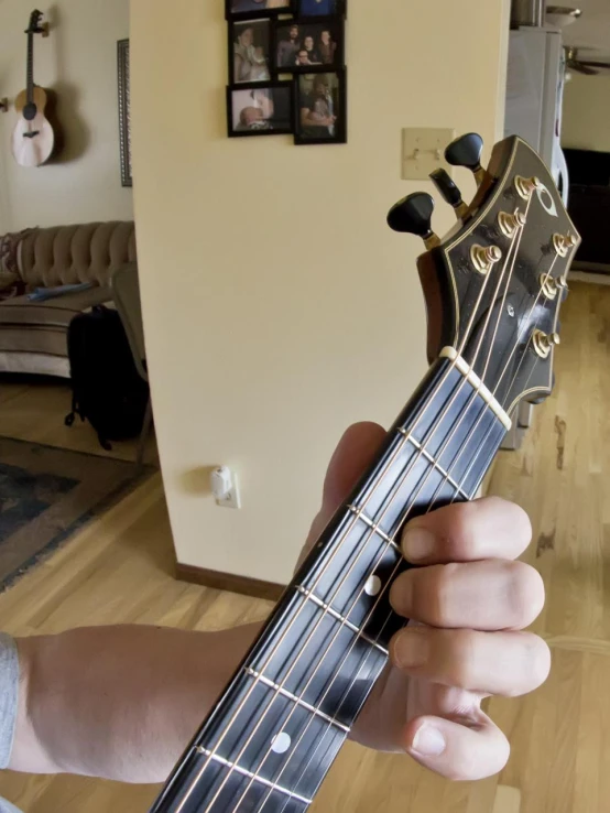 a man is holding up an acoustic guitar