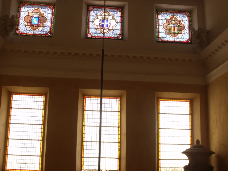 three stained glass windows on the wall in a room