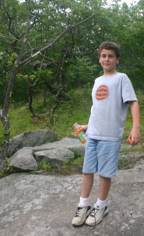 a young man holding an orange kite in his hand