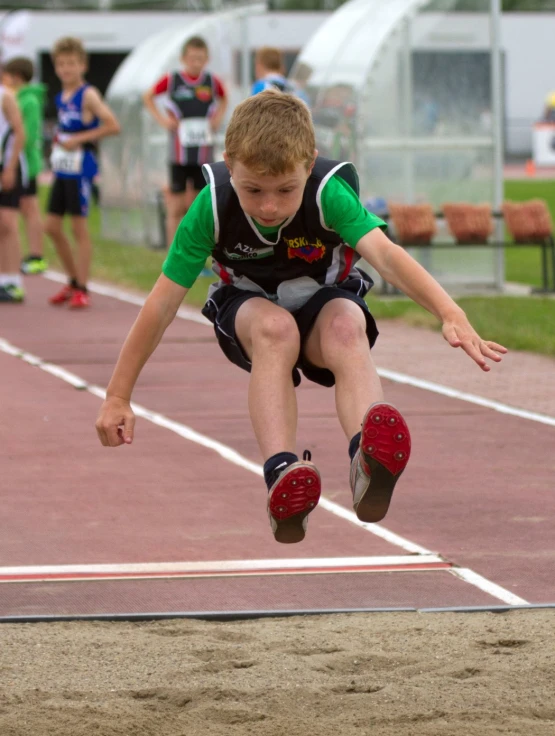 the young man is jumping off a jump on the track