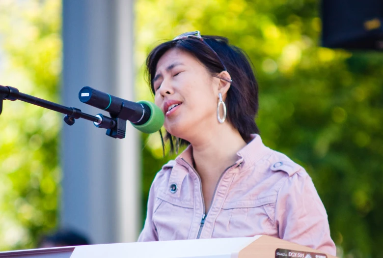 a woman that is standing up near a microphone