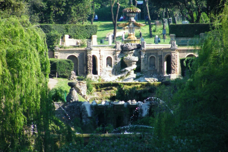 a lush green park with a tall stone building