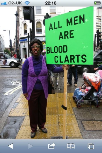 a woman standing on a sidewalk next to a sign
