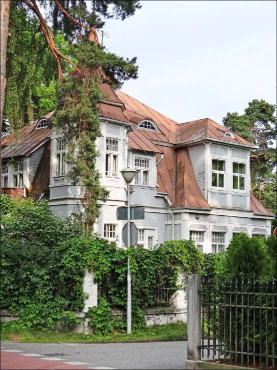 a house on the side of the road with a metal fence