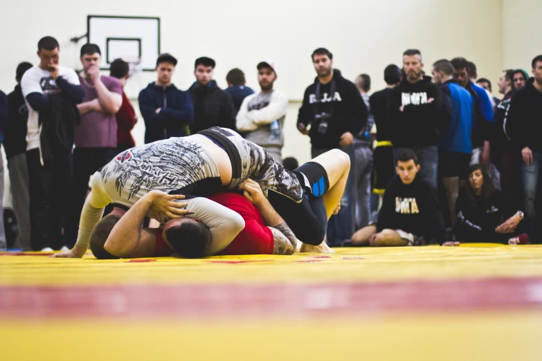 wrestlers compete in a wrestling competition as other watch