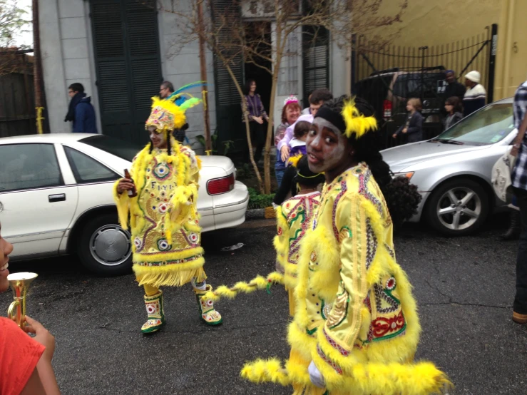 performers in brightly colored costumes dance on the street