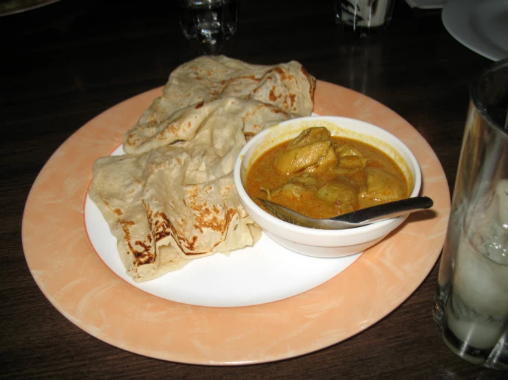 a plate with tortilla next to a bowl of soup