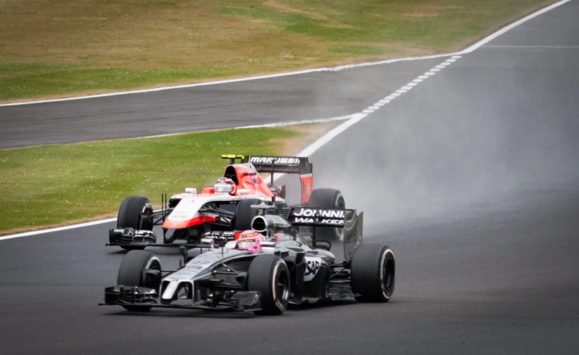 the car of two racing drivers in motion on a race track