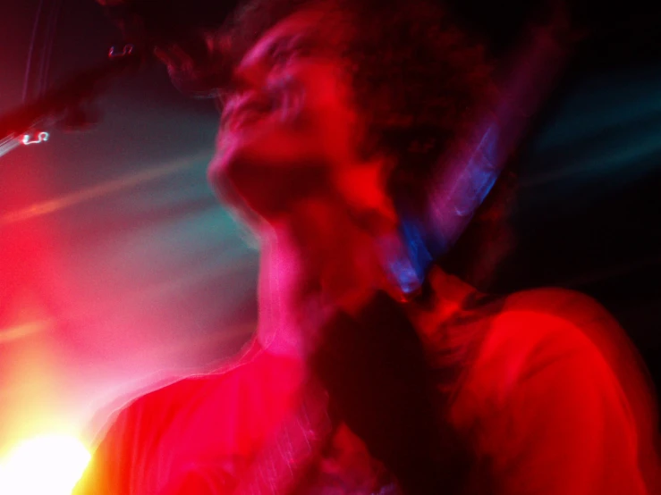 a man in a white shirt singing into a microphone