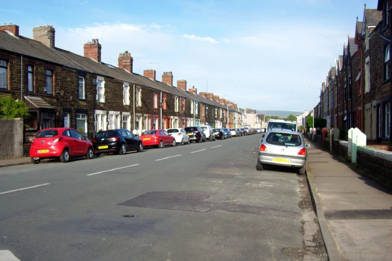 cars parked on both sides of the street with buildings next to it