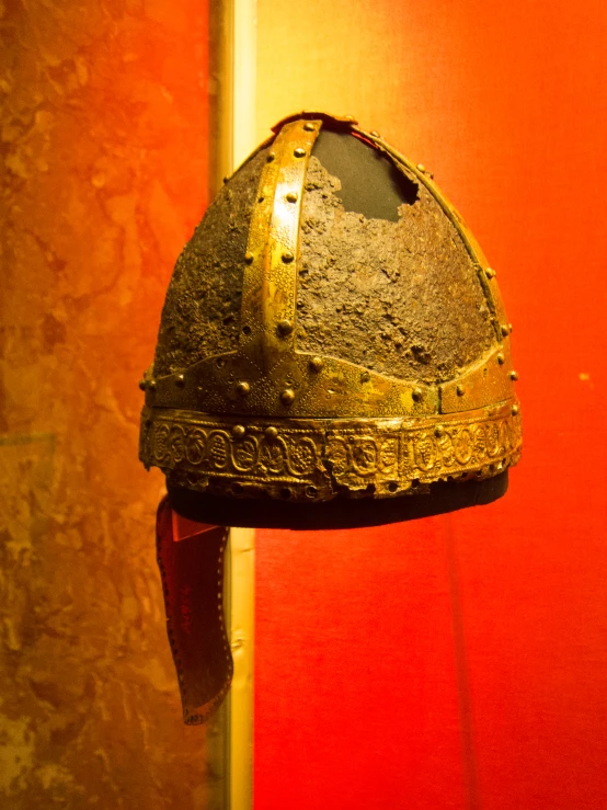 an old helmet is next to an orange wall