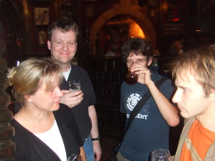 four people posing for a po with wine glasses