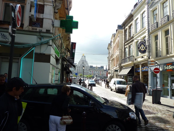 people on the side walk near parked cars