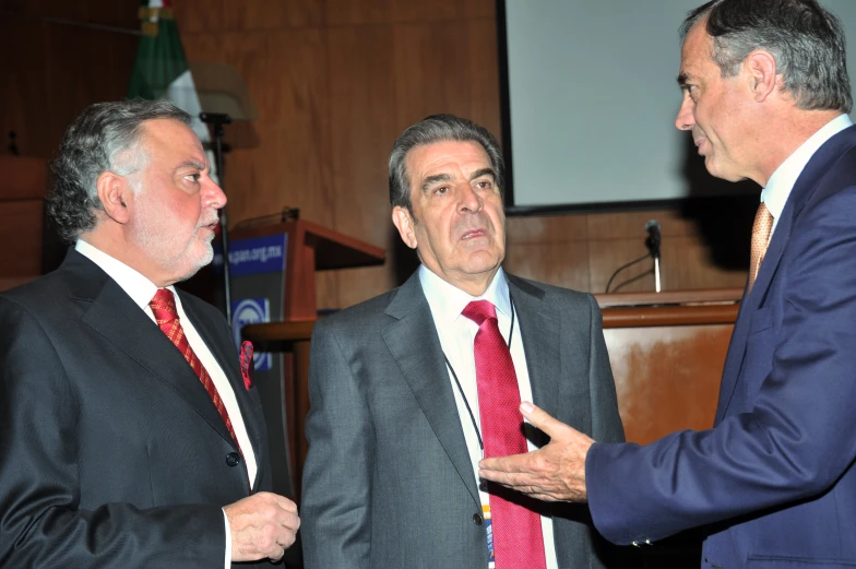 two men in business suits with one holding soing in his hand