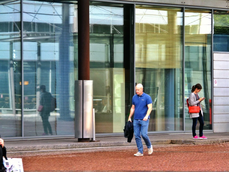 three people walking outside an office building with glass windows