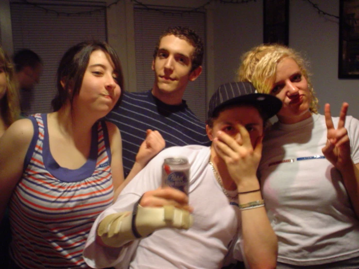 group of friends standing in the kitchen showing victory sign