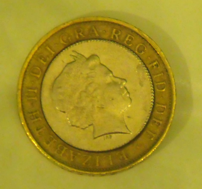 the face of a one dollar coin is shown in gold