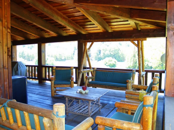 a porch with two wooden chairs and a table