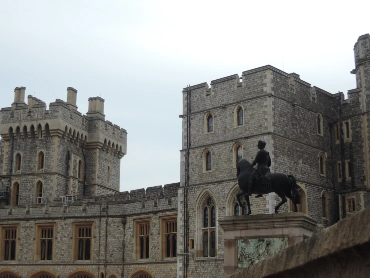 a statue on top of a horse in front of a building