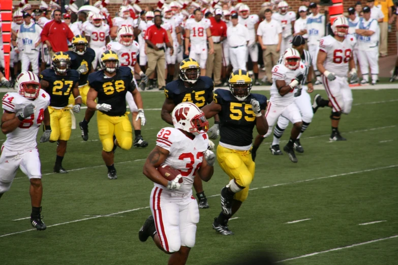 a group of men running on a field with helmets