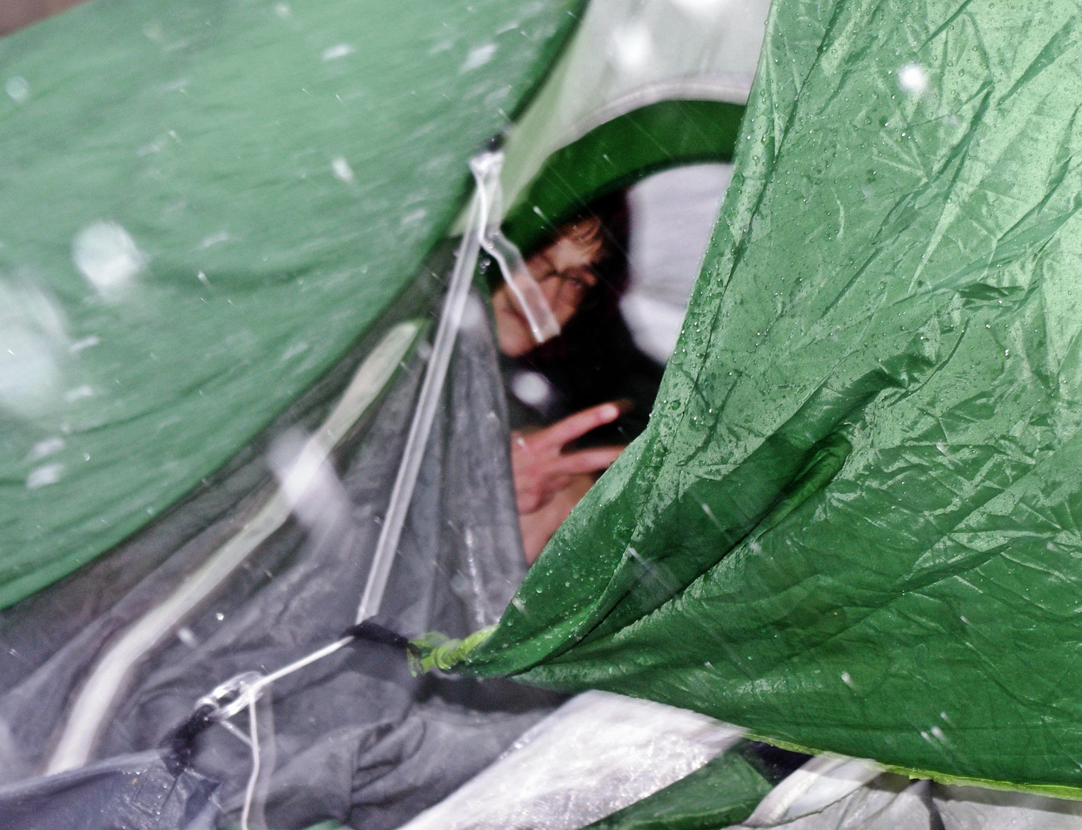 a person using their cell phone in a tent